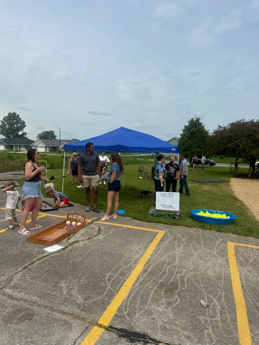 Families and lawn games across the grounds at dusk during the Backyard Market