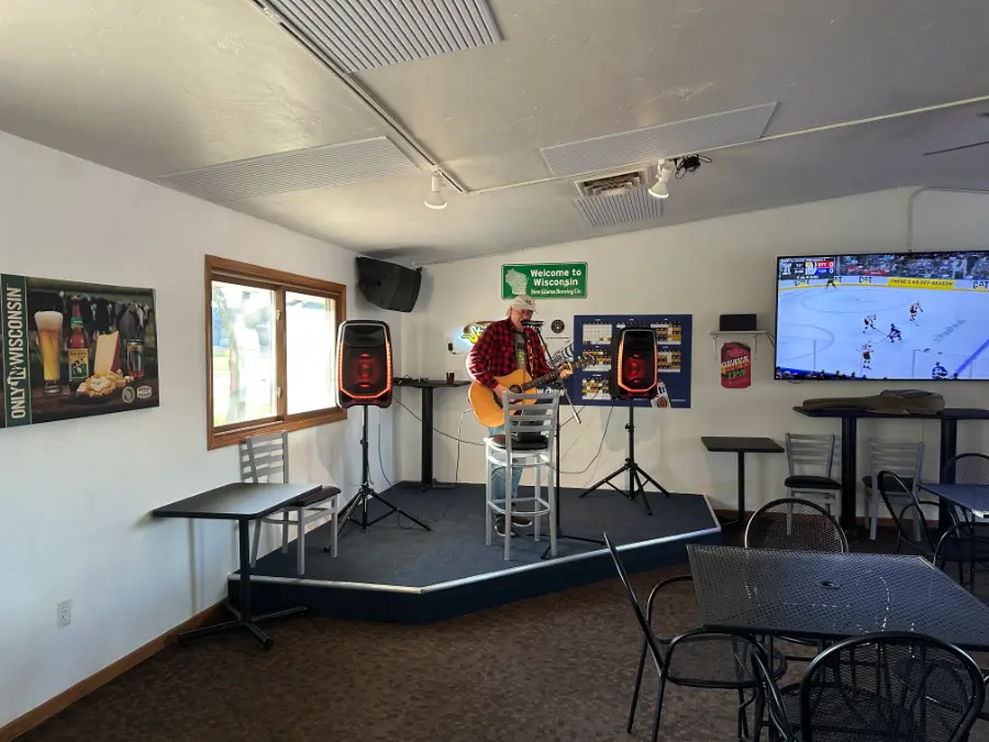 A local musician playing live on the stage inside Backyard Brew